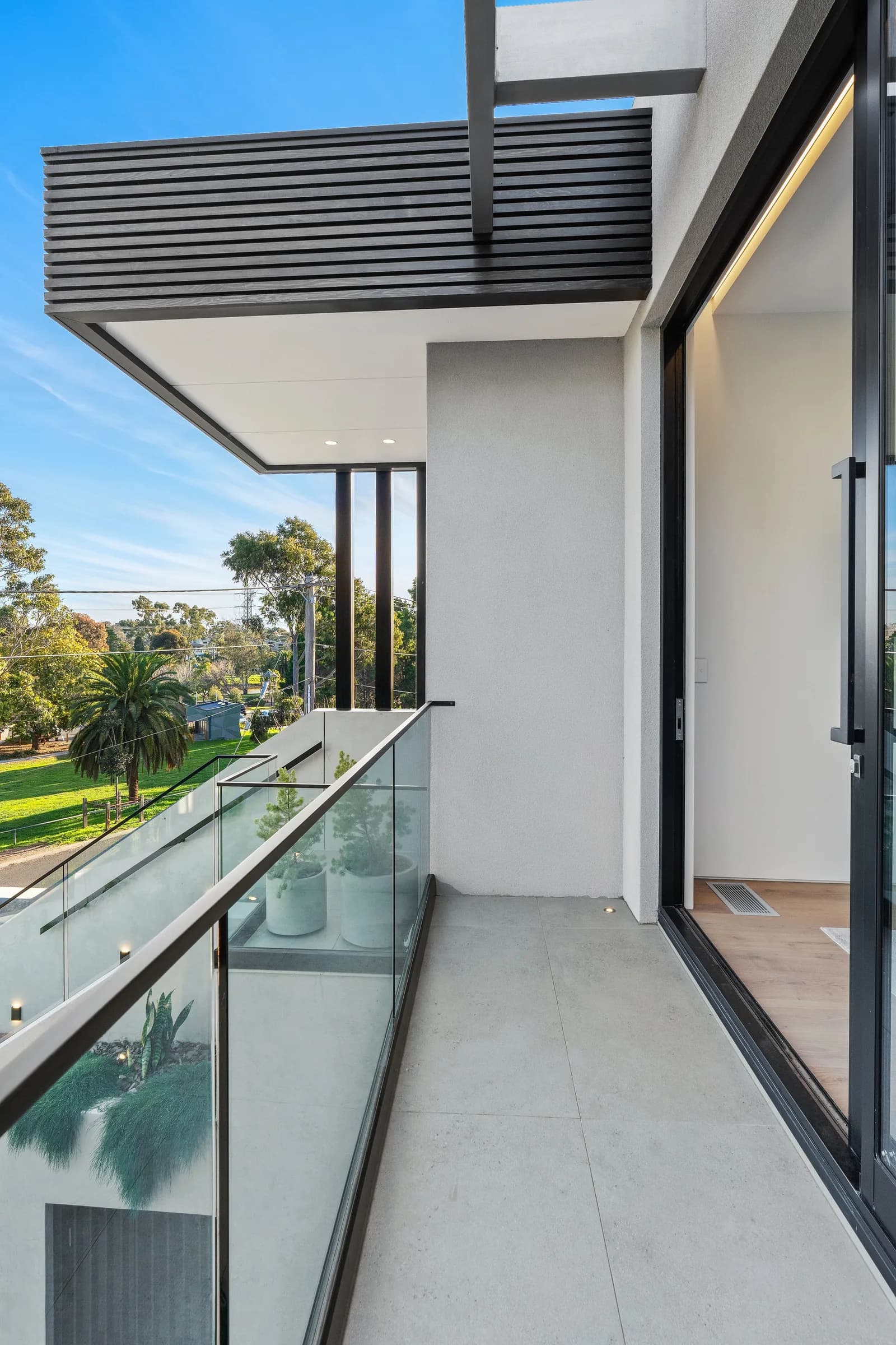 First-floor balcony with glass balustrade and park outlook