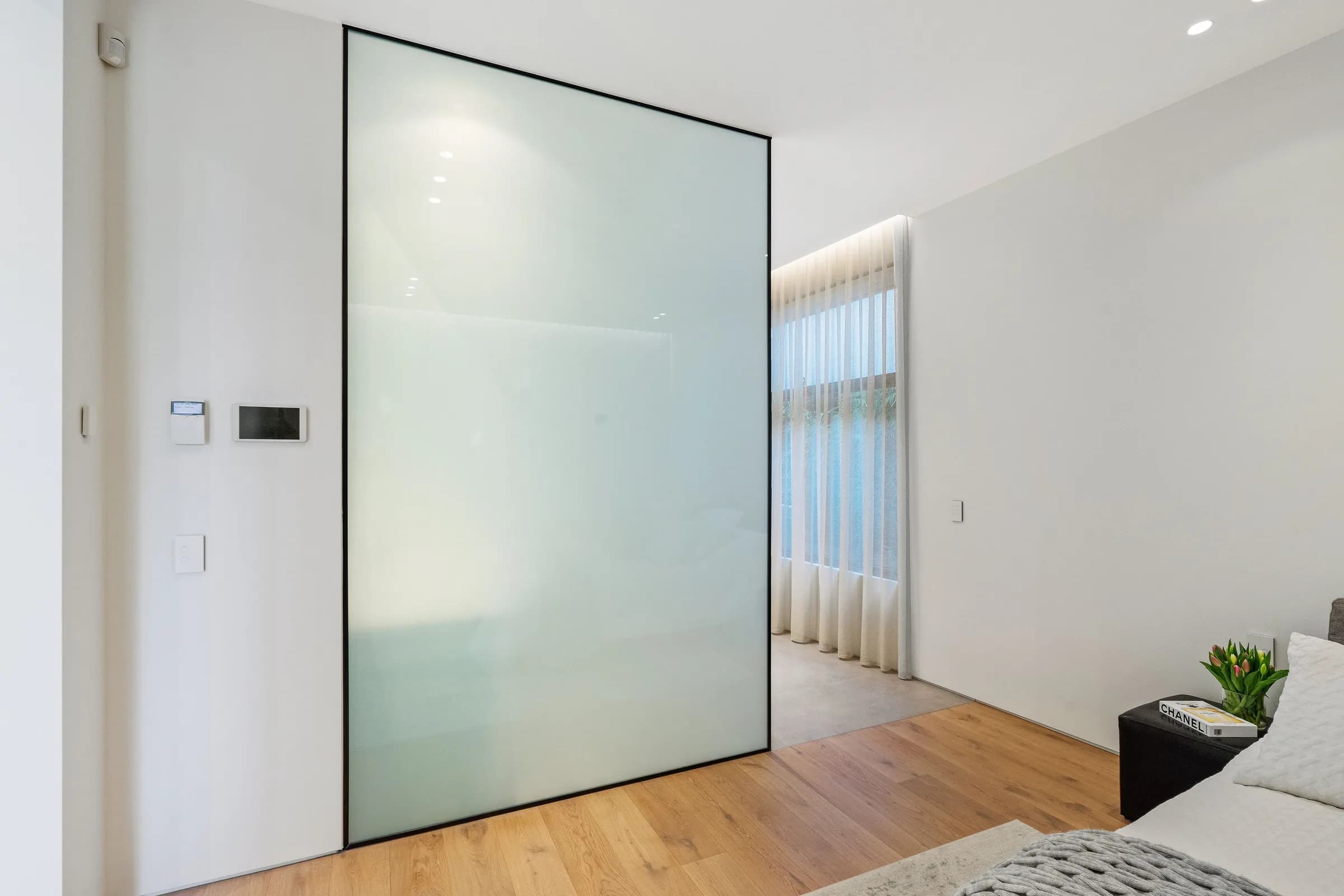 Frosted glass wall panel beside a bedroom with oak floor
