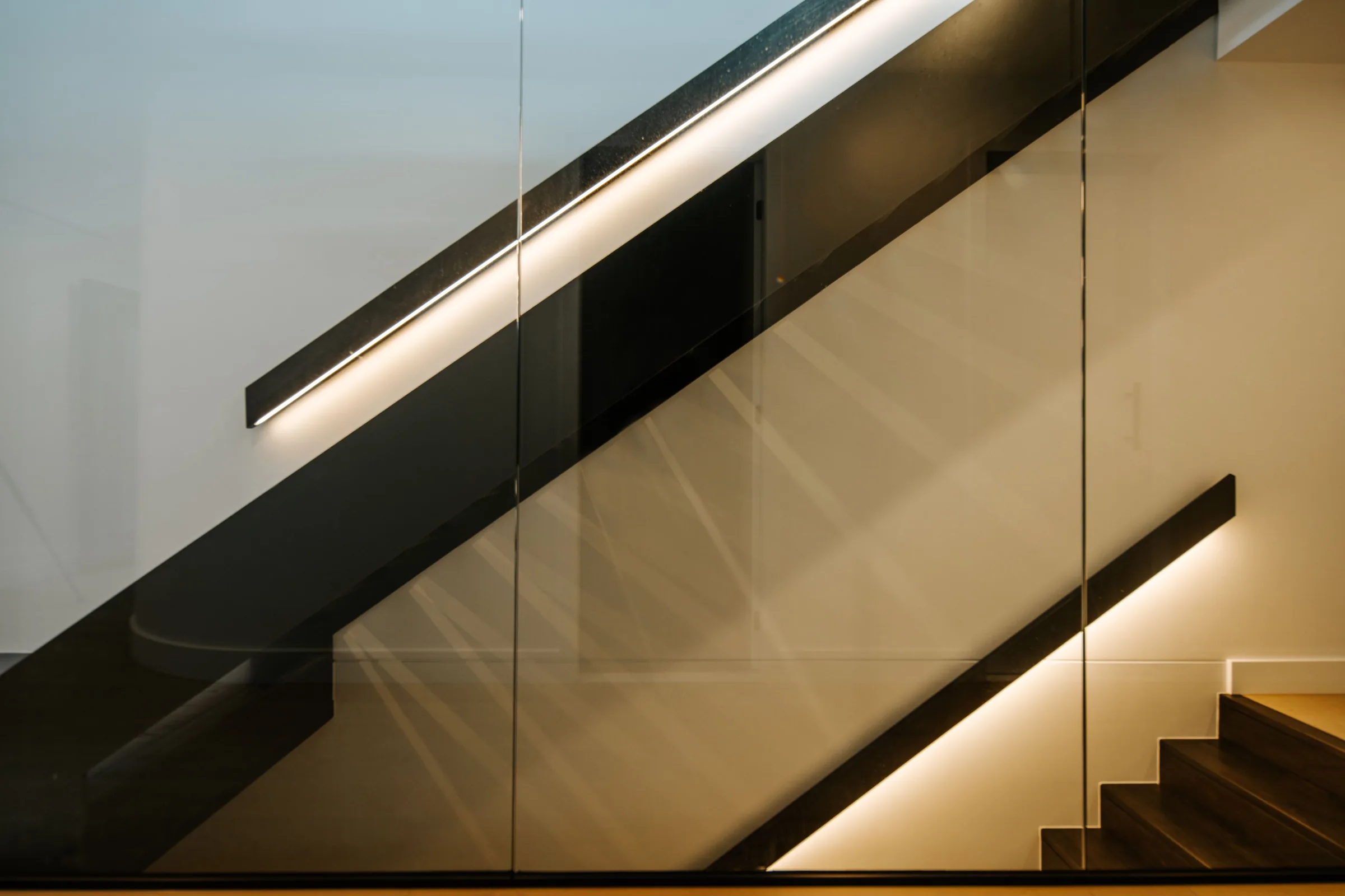 Dark stair with lit timber handrail detail