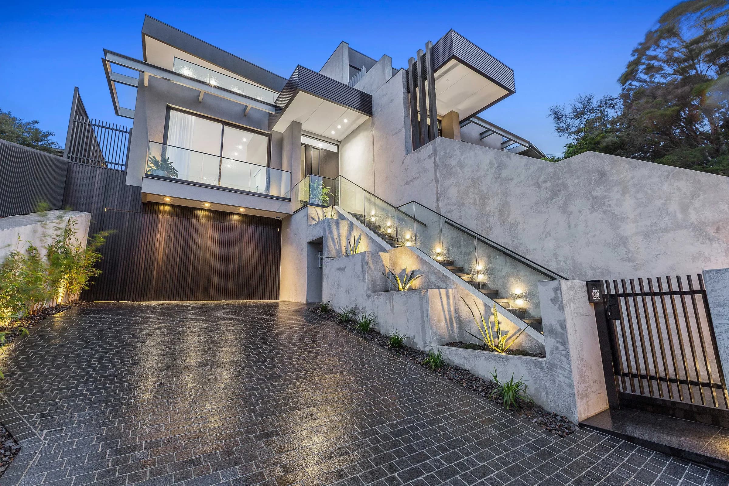Concrete and timber home at dusk with warm lighting