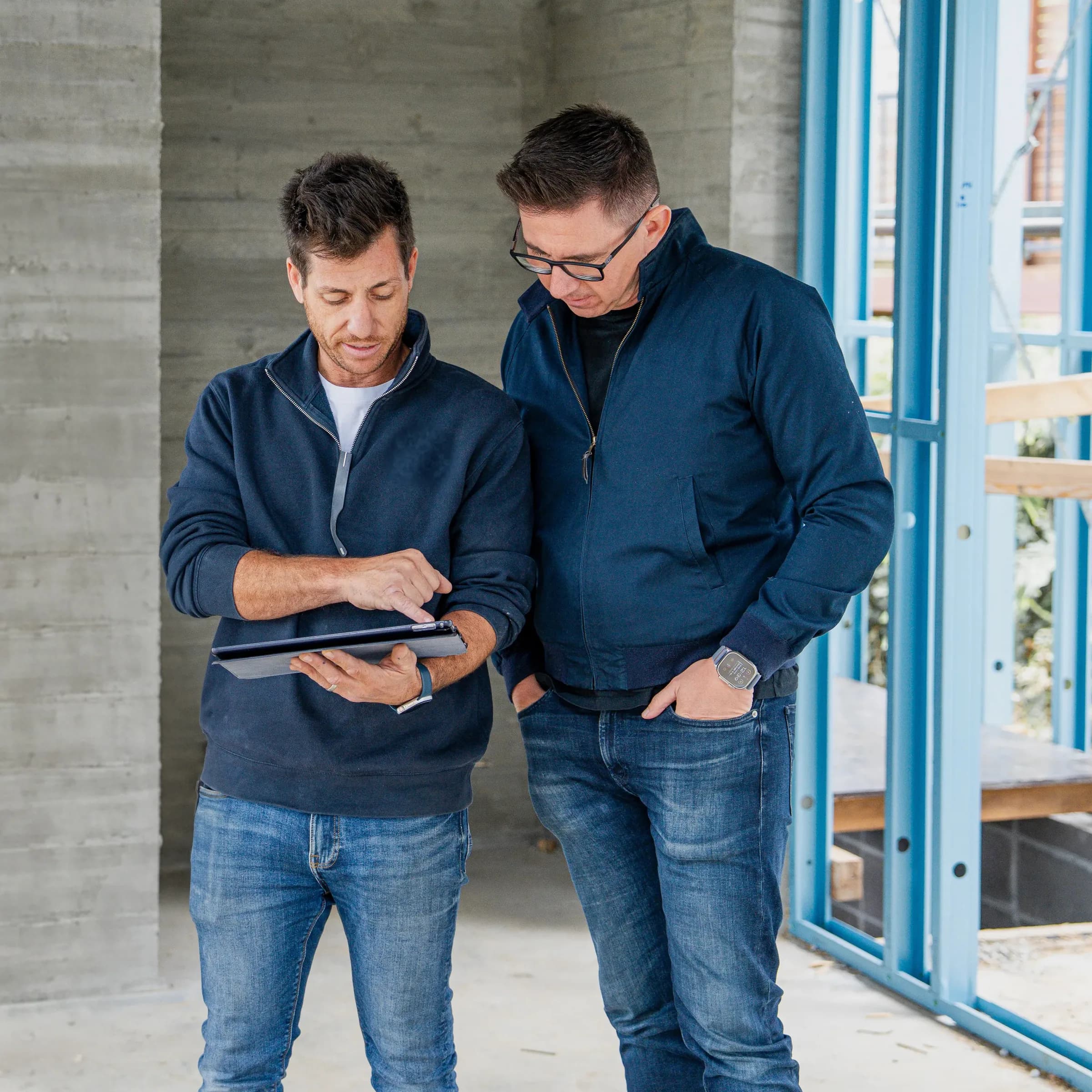Terry and Lachlan reviewing plans on a tablet during a site visit
