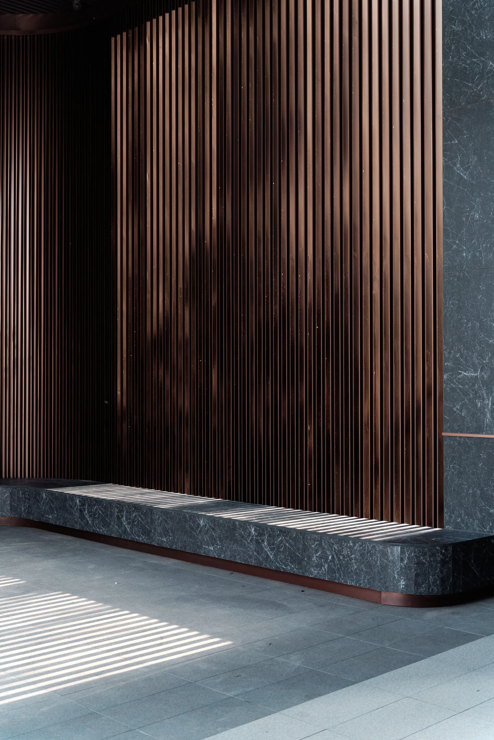 Smoked timber slat wall with stone bench seat