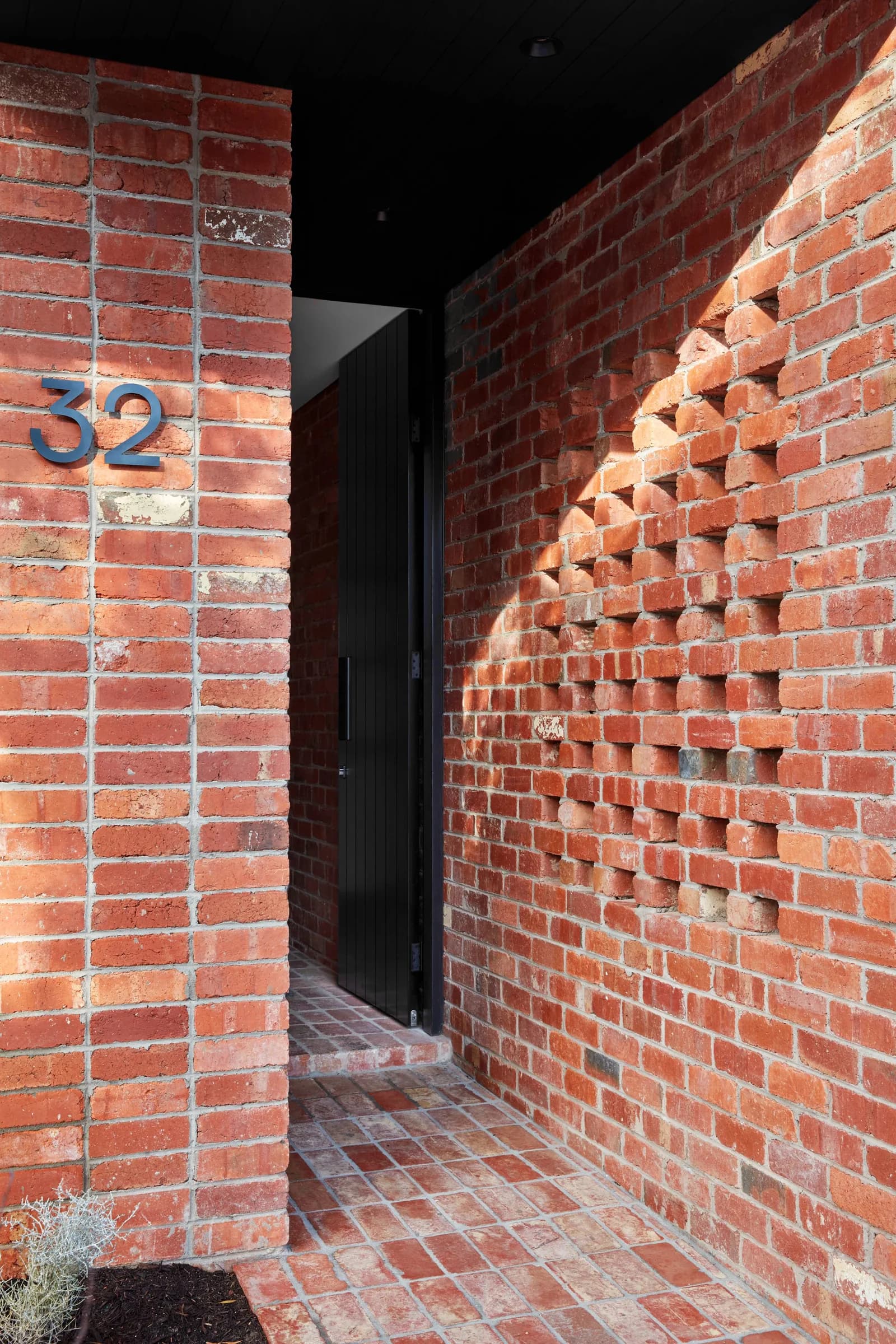 Recycled red brick entry with hit-and-miss coursing and number 32 in steel
