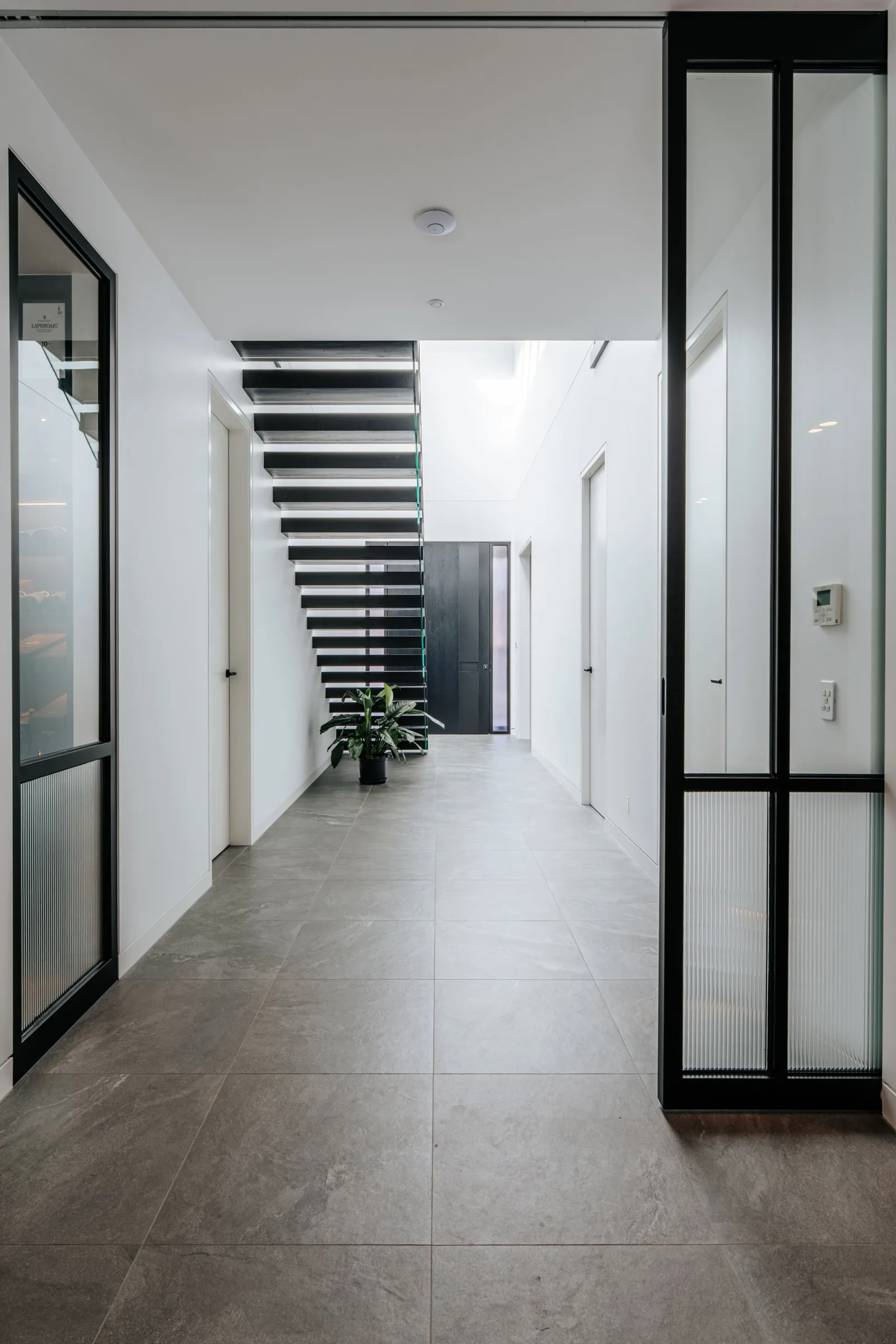 Steel-framed glass doors along a tiled hallway