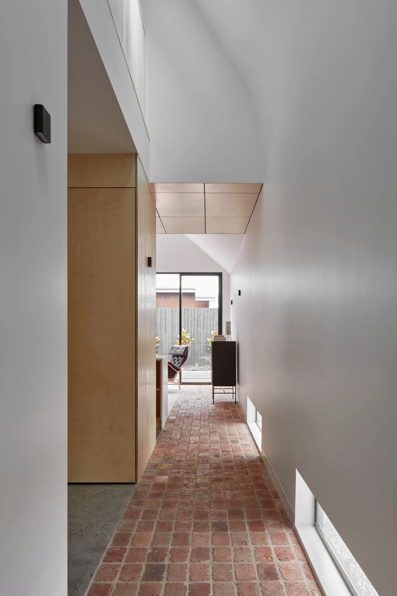 Plywood hallway with recycled brick paver floor